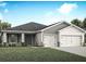 Charming single-story home with gray siding, well-manicured lawn, and a two-car garage at 2422 White Ladyfish Rd, Wimauma, FL 33598