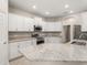 Modern kitchen with white cabinets, stainless steel appliances, and a large center island with granite countertops at 2422 White Ladyfish Rd, Wimauma, FL 33598