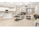 Bright and open-concept living space with wood flooring, modern furniture, and seamless flow to the kitchen at 2422 White Ladyfish Rd, Wimauma, FL 33598