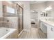 Elegant bathroom with a glass-enclosed shower, soaking tub, dual sinks, and modern fixtures at 2422 White Ladyfish Rd, Wimauma, FL 33598