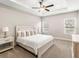 Cozy main bedroom with a tray ceiling, neutral decor, carpet flooring, and large windows at 2422 White Ladyfish Rd, Wimauma, FL 33598