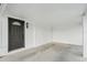 An enclosed carport with gray concrete flooring and a dark gray door with an arched window at 275 Garden Rd, Venice, FL 34293