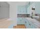 Cozy kitchen featuring tile countertops, light-blue cabinets, and modern fixtures at 275 Garden Rd, Venice, FL 34293