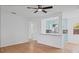 Bright living room with beautiful wood floors, a ceiling fan, and an open view to the kitchen at 275 Garden Rd, Venice, FL 34293