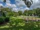 Lush backyard space that includes garden beds, various trees, and green lawn, creating a serene outdoor setting at 2802 Midway Rd, Plant City, FL 33565