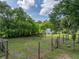 Spacious backyard surrounded by lush greenery, including a small white shed and a rustic wooden fence at 2802 Midway Rd, Plant City, FL 33565