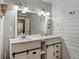 Charming bathroom with dual sinks, white cabinets, wood-style walls, and decorative lighting at 2802 Midway Rd, Plant City, FL 33565