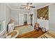 Bright bedroom with hardwood floors, a ceiling fan, closet, and a decorative wood paneled wall behind a white fireplace at 2802 Midway Rd, Plant City, FL 33565
