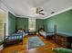Comfortable bedroom features a hardwood floor and warm-toned green walls, offering a cozy and inviting atmosphere at 2802 Midway Rd, Plant City, FL 33565