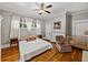 Comfortable bedroom with wood floors, white trim, a ceiling fan, and a crib at 2802 Midway Rd, Plant City, FL 33565