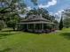 Charming two-story home featuring a welcoming front porch and mature landscaping on a sunny day at 2802 Midway Rd, Plant City, FL 33565