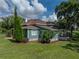 Side view of a charming home showcasing the lush green lawn, large trees, and a wrap-around porch at 2802 Midway Rd, Plant City, FL 33565