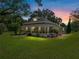 Charming two-story home featuring a welcoming front porch and mature landscaping with a colorful sunset backdrop at 2802 Midway Rd, Plant City, FL 33565