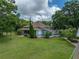 Wide view of a charming home showcasing the lush green lawn, large trees, and a wrap-around porch at 2802 Midway Rd, Plant City, FL 33565