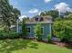 Side view of a charming home showcasing the lush green lawn and mature trees surrounding the property at 2802 Midway Rd, Plant City, FL 33565