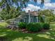 Back view of a charming home showcasing the lush green lawn and mature trees surrounding the property at 2802 Midway Rd, Plant City, FL 33565