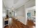 Inviting hallway with beautiful wood floors, wainscoting, and decorative light fixture at 2802 Midway Rd, Plant City, FL 33565