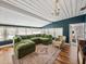 Comfortable living room featuring a plush green sectional, hardwood floors, and elegant chandelier lighting at 2802 Midway Rd, Plant City, FL 33565
