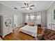 Bright and airy bedroom with hardwood floors, ceiling fan, and large windows dressed with white curtains at 2802 Midway Rd, Plant City, FL 33565