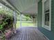 Inviting porch featuring wooden floors and views of the surrounding greenery at 2802 Midway Rd, Plant City, FL 33565