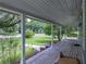 Long, covered porch with white support columns offers ample space to sit and enjoy the serene, landscaped front yard at 2802 Midway Rd, Plant City, FL 33565