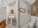Stylish powder room with pedestal sink, decorative mirror, and rustic wood accent wall at 2802 Midway Rd, Plant City, FL 33565