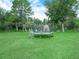 Beautiful backyard featuring a trampoline, shed, mature trees, and lush green grass for outdoor activities at 2815 Kebs Ln, Plant City, FL 33565