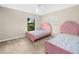 Bedroom showcasing two pink beds, soft carpet, and a bright ceiling fan at 2815 Kebs Ln, Plant City, FL 33565