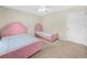 Bedroom showcasing two pink beds, soft carpet, and a bright ceiling fan at 2815 Kebs Ln, Plant City, FL 33565