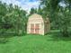 Quaint storage shed in a lush green backyard with trees and manicured grass at 2815 Kebs Ln, Plant City, FL 33565