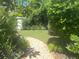 Green backyard featuring a stone pathway, with verdant lawns, mature trees and a shed for storage at 4718 Crystal Ave, Sarasota, FL 34231