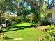 Lush backyard featuring a well-maintained lawn, mature trees, and decorative landscaping, creating a private oasis at 4718 Crystal Ave, Sarasota, FL 34231