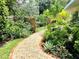 Scenic backyard with lush landscaping, stone pathway, and a decorative gate, offering a tranquil retreat at 4718 Crystal Ave, Sarasota, FL 34231