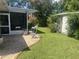 Beautiful backyard with a screened patio, green lawn, mature trees, and a shed, perfect for outdoor living at 4718 Crystal Ave, Sarasota, FL 34231