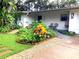 Charming home featuring a beautifully landscaped front yard with colorful plants and brick-lined garden beds at 4718 Crystal Ave, Sarasota, FL 34231