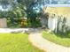 Charming home featuring a white exterior, stone pathway, and verdant landscaping at 4718 Crystal Ave, Sarasota, FL 34231
