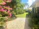 Landscaped side yard featuring a stone path, lush greenery, and flowering plants at 4718 Crystal Ave, Sarasota, FL 34231