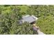 Aerial view from above some trees of the roof of a home and some outbuildings at 1309 Joe Mcintosh Rd, Plant City, FL 33565