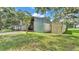 Exterior angle shot of barn with open doors and covered area with grass and oak trees around it at 1309 Joe Mcintosh Rd, Plant City, FL 33565