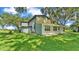 Angle view of the house with lush green grass and large trees near the property at 1309 Joe Mcintosh Rd, Plant City, FL 33565