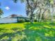 Lush backyard featuring a playhouse under mature trees and a privacy fence at 173 Portland Ave, Spring Hill, FL 34606