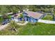 Inviting blue home with a well-manicured lawn, solar panels, and a convenient two-car garage at 173 Portland Ave, Spring Hill, FL 34606