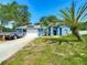 Charming blue home with a well-manicured lawn, a mature palm tree and solar panels on the roof at 173 Portland Ave, Spring Hill, FL 34606