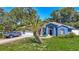 Charming blue home featuring manicured lawn, mature trees, and a spacious driveway at 173 Portland Ave, Spring Hill, FL 34606