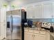 Spacious kitchen with stainless steel refrigerator, white cabinets, and granite countertops at 173 Portland Ave, Spring Hill, FL 34606