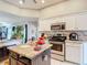 Well-equipped kitchen with stainless steel appliances and an island with marble countertop at 173 Portland Ave, Spring Hill, FL 34606