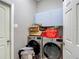 Laundry room with modern washer, dryer, and overhead storage cabinets at 173 Portland Ave, Spring Hill, FL 34606