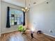 Spacious living room featuring a large window, chandelier, and durable hardwood flooring at 173 Portland Ave, Spring Hill, FL 34606