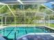 Sparkling pool with screened enclosure and lush greenery beyond at 173 Portland Ave, Spring Hill, FL 34606