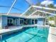Gorgeous screened pool with sun shelf and covered patio, perfect for outdoor relaxation and entertaining at 173 Portland Ave, Spring Hill, FL 34606